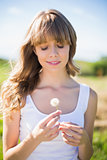 Relaxed young woman holding dandelion