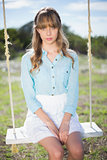 Angelic natural young woman sitting on swing