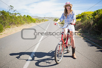 Happy pretty model posing while riding bike