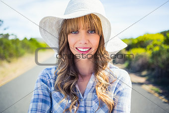 Cheerful young woman posing while walking on the road
