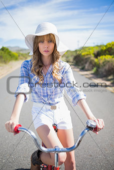 Mysterious young woman posing while riding bike