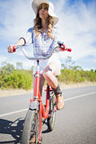 Thoughtful young woman posing while riding bike