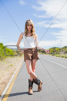 Mysterious attractive woman posing while hitchhiking