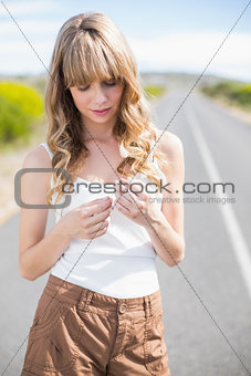 Pretty woman holding flower while walking on the road