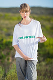 Natural young blonde pointing at her volunteering t shirt