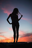 Silhouette of attractive woman posing on the beach