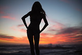 Silhouette of slim woman posing on the beach