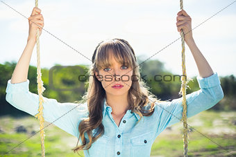 Trendy attractive woman sitting on swing
