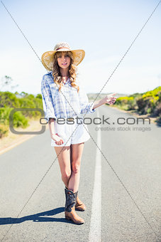 Pretty blonde hitchhiking on the road