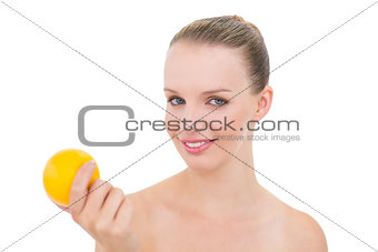 Joyful pretty blonde model holding an orange