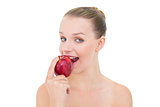 Amused pretty blonde model eating an apple