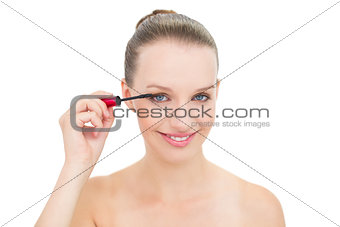 Joyful pretty blonde model applying mascara