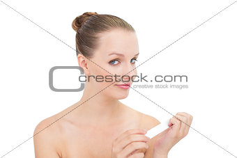 Smiling pretty blonde model filing her nails