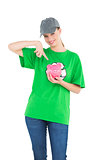 Smiling pretty environmental activist showing a piggy bank