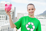 Content pretty environmental activist holding a piggy bank