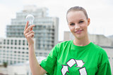 Content pretty environmental activist holding a light bulb