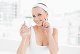 Pensive pretty sportswoman holding a glass of water