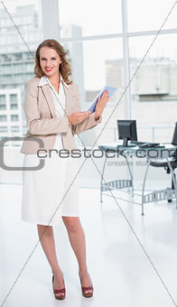 Happy pretty businesswoman holding a tablet pc