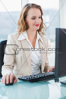 Smiling pretty businesswoman using a computer