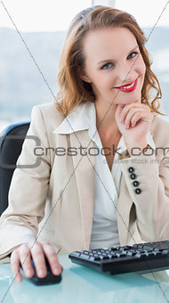 Pensive pretty businesswoman smiling and looking at camera