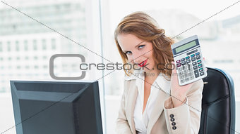 Relaxed pretty businesswoman holding a calculator