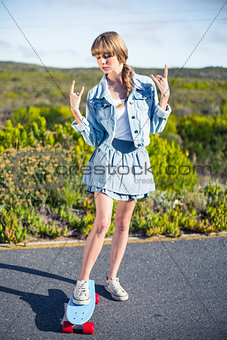Attractive blonde making rock and roll hand gesture