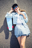 Smiling blonde skater lying on the highway