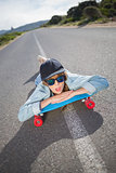 Funky young woman lying on a deserted road