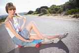 Pouting funky blonde sitting on her skateboard