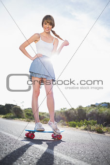 Happy young woman balancing on her skateboard