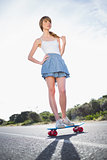 Cool skater girl doing standing on her skateboard