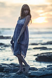 Beautiful model posing on rocks by the sea