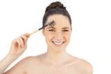 Smiling sensual model using eyebrow brush