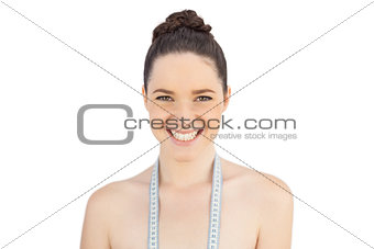 Smiling sensual model with measuring tape on shoulders
