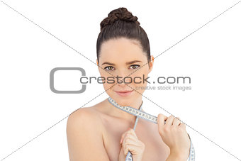 Sensual model with measuring tape on shoulders posing
