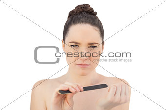 Serious pretty model filing her fingernails