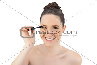 Cheerful pretty model applying mascara