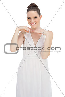 Smiling young model in white dress posing