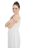 Cheerful young model in white dress posing