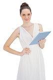 Young model in white dress holding tablet computer