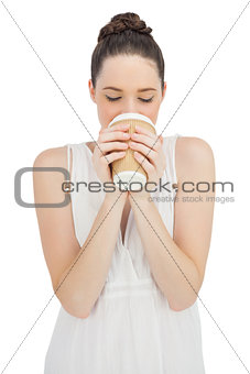 Natural model in white dress drinking coffee