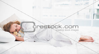 Sleeping pretty woman embracing her stuffed animal