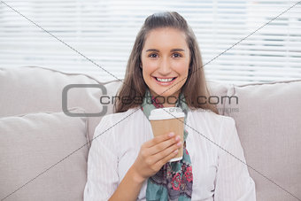 Smiling pretty model holding mug of coffee