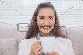 Smiling pretty model holding cup of coffee