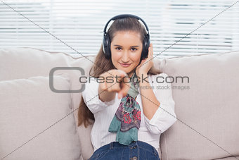 Peaceful cute model pointing at camera listening to music