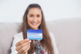 Cheerful young model holding her credit card