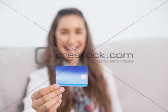 Happy young model holding her credit card