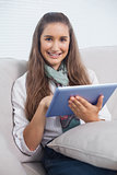 Smiling attractive brunette using her tablet computer