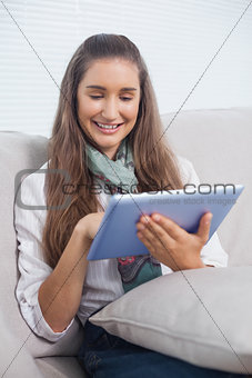 Cheerful attractive brunette using her tablet computer