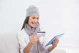 Smiling pretty brunette with winter hat on buying online